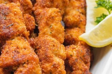 Breaded Chicken Skewers with lemon wedges served on platter