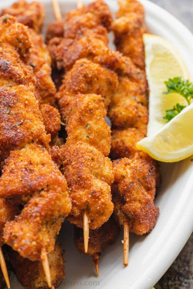 Breaded Chicken Skewers with lemon wedges served on platter