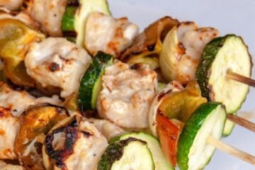 Grilled garlic chicken skewers on a white plate