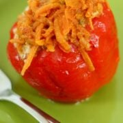 A stuffed bell pepper on a green plate