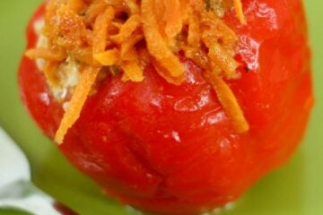 A stuffed bell pepper on a green plate