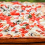 A close up of a chicken pizza with creamy garlic sauce