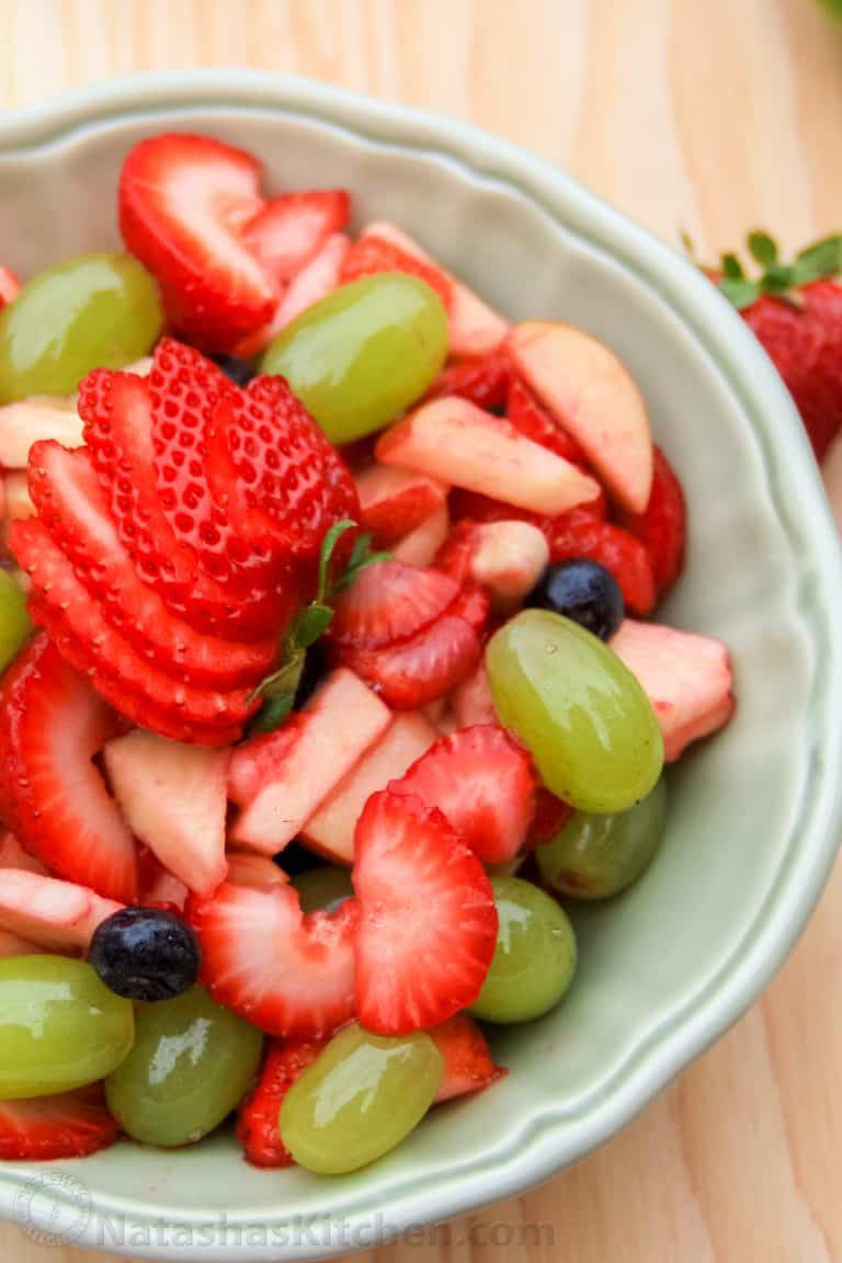 A bowl of fruit salad with citrus and honey syrup