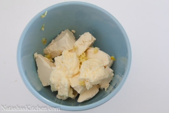A blue bowl with cows cheese, mayo and grated garlic 