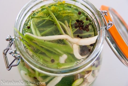 A close up of a glass jar with pickles 