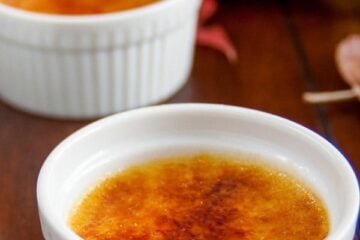 Two white glass bowls with pumpkin creme br&ucirc;l&eacute;es