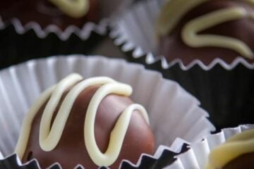 The center is a traditional Russian sponge cake called biskvit which is mixed with cooked poppy seeds and sweetened condensed milk. They are coated in melted chocolate truffles and made pretty with white chocolate.