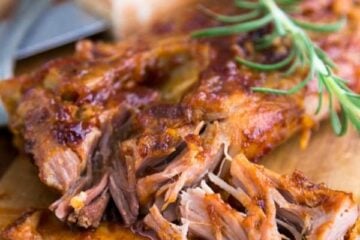 Fall off the bone ribs on a cutting board garnished with rosemary
