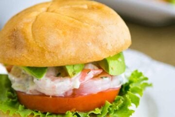 A close up shrimp sandwich on a white plate