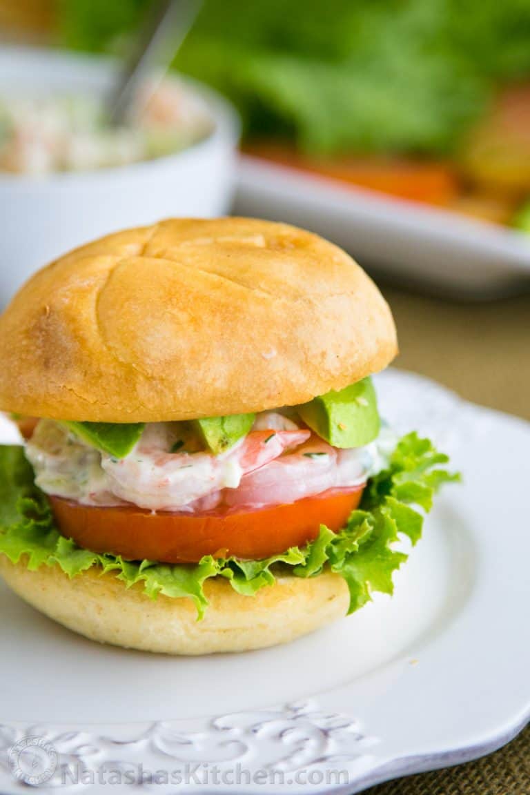 A close up shrimp sandwich on a white plate