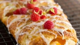 You'll make this braided danish again and again. It has a cheesecake center and is loaded with peaches. This braided danish is easier than you think! How To make braided danish | natashaskitchen.com