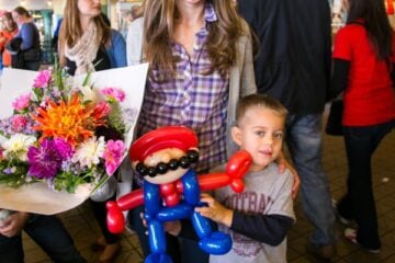 Natasha holding flowers and her son holding a ballon Mario at Pike Place Market