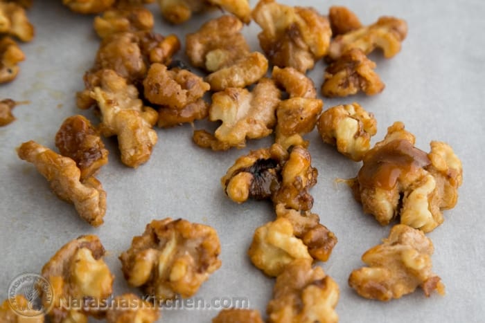 Up close candied walnuts separated on parchment paper