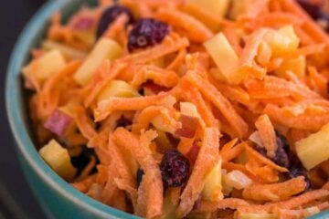 A close up of a bowl of carrot and apple salad