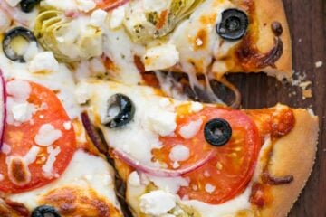A pizza sitting on top of a wooden cutting board