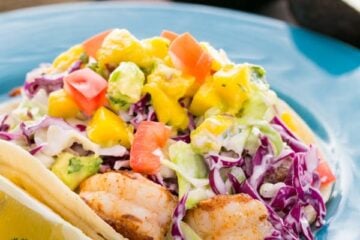 These Shrimp Tacos with Coconut Coleslaw & Mango Salsa are a yummy mouthful. Inspired by the famous fish tacos at Coconut's Fish Cafe in Maui.