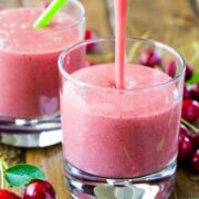 A close up two glasses with strawberry and cherry smoothies