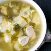 A white bowl of shchavel borshct, sorrel soup