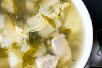 A white bowl of shchavel borshct, sorrel soup