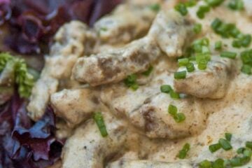 A plate of Russian beef stroganoff garnished with chives