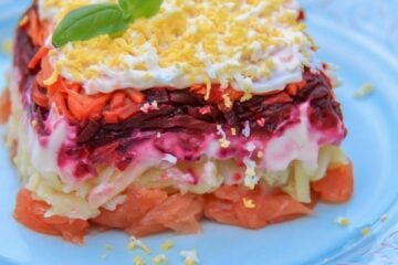 A piece of shuba with salmon on a white plate