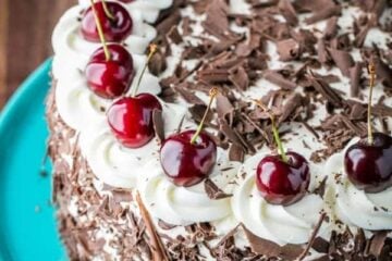 Black Forest Cake (a famous German Chocolate Cake) with 4 chocolatey layers, 1 lb of kirsch infused cherries and whipped cream. So good!! | NatashasKitchen.com