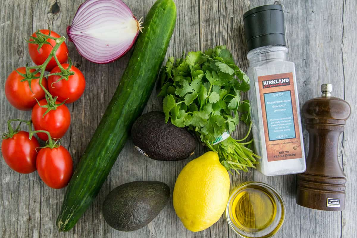 Cucumber Tomato Avocado Salad ingredients with fresh veggies and dressing