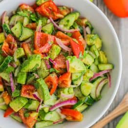 Cucumber Tomato Avocado Salad served in a white bowl