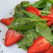 Spinach strawberry salad on a white plate