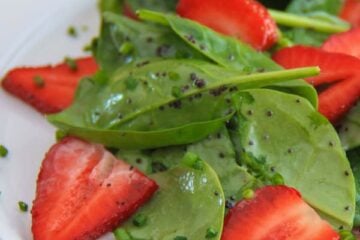 Spinach strawberry salad on a white plate