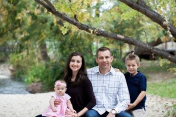 Natasha's family sitting on a bench at a river bed