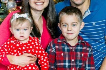 Natasha's family sitting in front of a Christmas tree