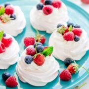 Pavlova served on a blue serving platter topped with berries