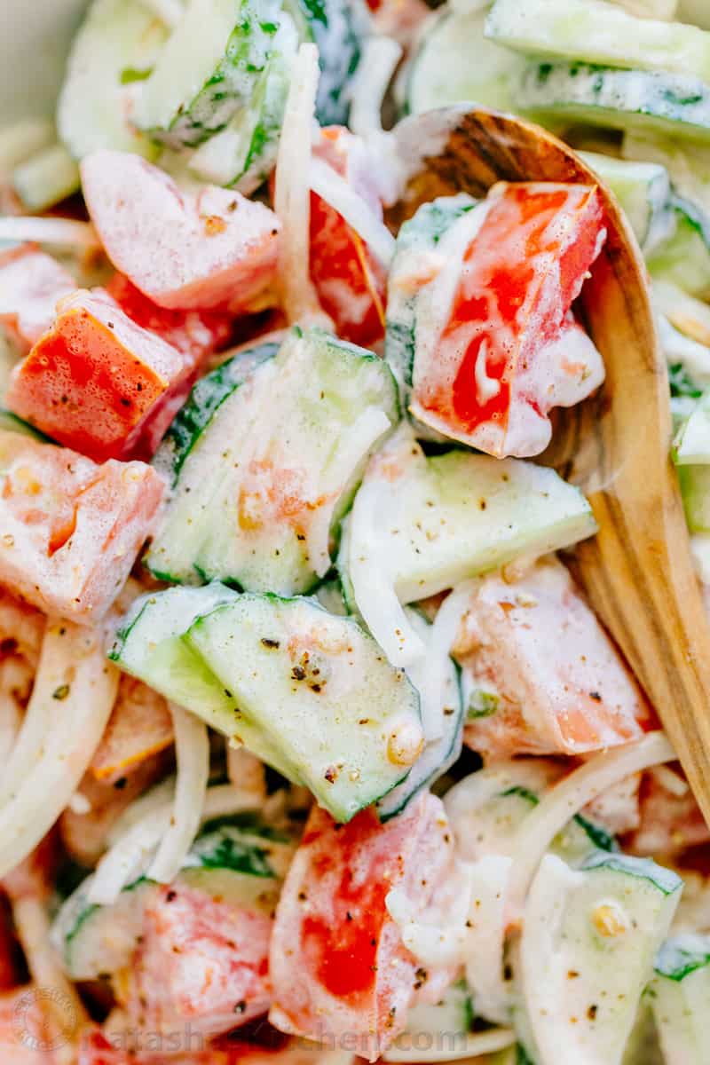 creamy cucumber tomato salad with sour cream-based dressing and pepper