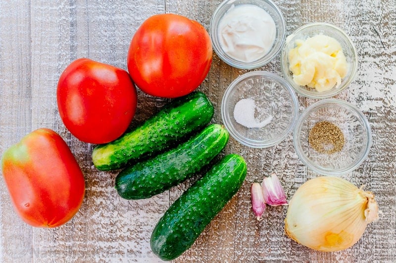 ingredients for summer salad with fresh garden veggies, mayo, sour cream, salt, pepper, garlic and onion