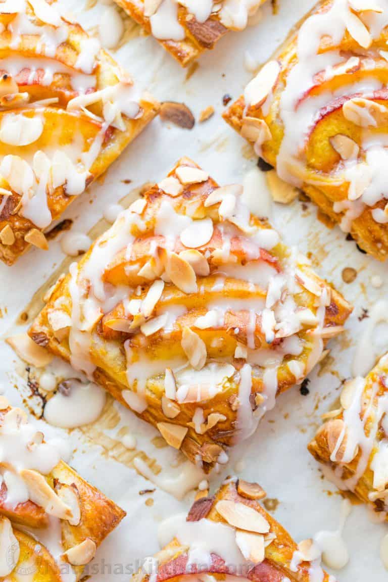 Peach tartlets with juicy peaches, toasted almonds & vanilla glaze over a flaky crust. Puff pastry peach tartlets always get RAVE REVIEWS! Easy, excellent.. | natashaskitchen.com