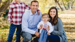 A photo of Natasha and her family in fall leaves