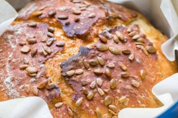 Loaf of bread baked in a dutch oven to make dutch oven bread covered with seeds
