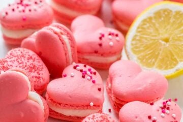 Heart Macarons are easier than you think! Heart-shaped macarons with tangy-sweet lemon buttercream. Includes video tutorial + free printable heart template! | natashaskitchen.com