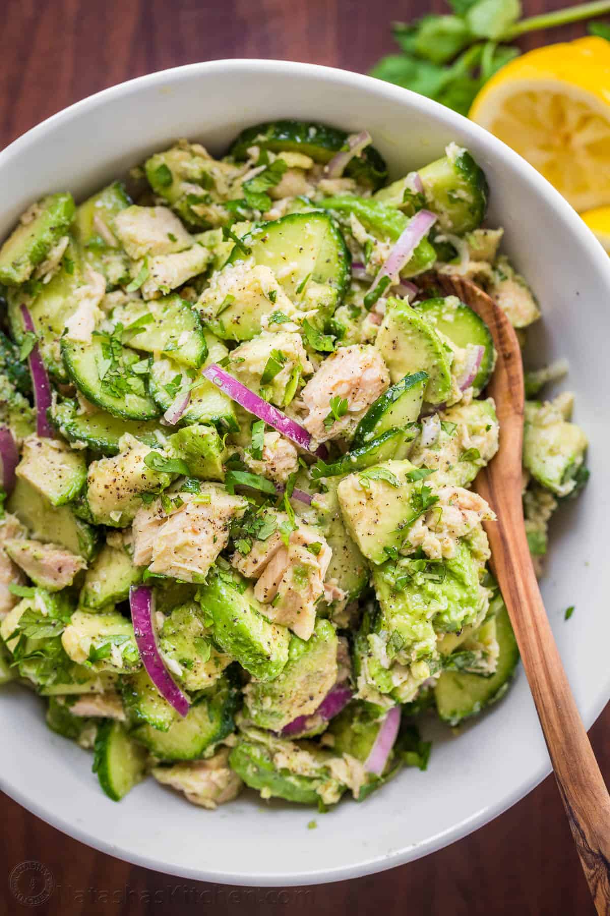 This Avocado Tuna Salad has incredible fresh flavor. It' is a high-protein salad and the avocado adds creaminess without any mayo. Avocado Tuna salad garnished with cilantro in a white serving bowl.