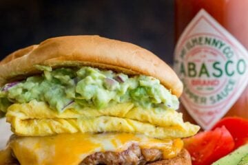 Spicy guacamole brunch sandwich with a crisp toasted bun, juicy sausage, melty cheese, fluffy eggs and guacamole! Easy guacamole breakfast sandwich! | natashaskitchen.com