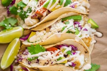 Our go-to fish tacos recipe for entertaining! Easy, excellent fish tacos with the best fish taco sauce; an irresistible lime crema! | natashaskitchen.com