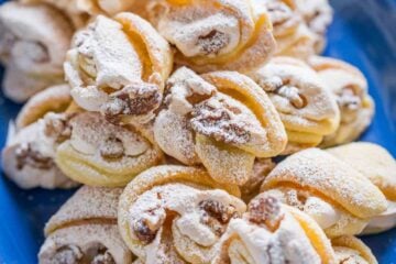 Meringue Shell Cookies have a crisp ribbon of meringue and soft crumbly center. These walnut meringue cookies are completely irresistible Christmas cookies! | natashaskitchen.com