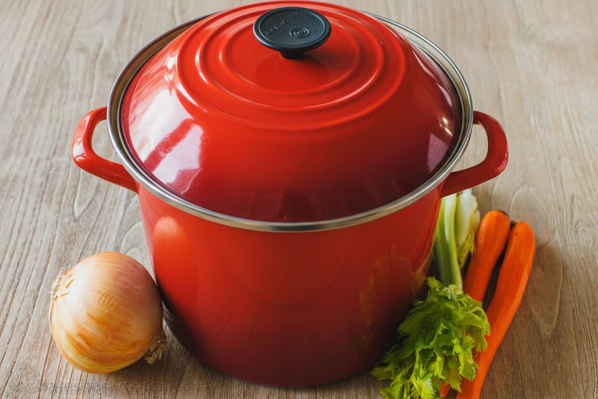 Easy homemade chicken stock tastes amazing in any recipe. Make this healthy Chicken Bone Broth on the stove, in the oven or in the Instant Pot Red stock pot with vegetables for cooking chicken stock