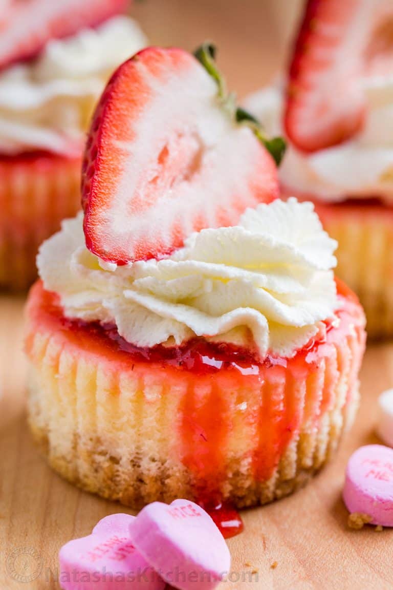 Mini strawberry cheesecakes are easy to make with simple ingredients. The texture in this strawberry cheesecake recipe is is creamy and smooth with a buttery crust. The fresh strawberry topping is irresistible. Valentine’s Day Dessert! | natashaskitchen.com