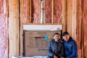 A couple sitting inside a house that is under construction