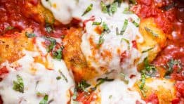 Stuffed Chicken Parmesan in a pan with marinara sauce and cheese topping