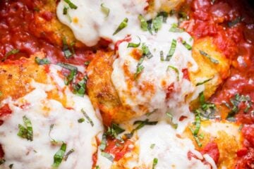 Stuffed Chicken Parmesan in a pan with marinara sauce and cheese topping