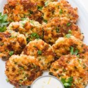 Cheesy Shrimp Cakes aka Shrimp Fritters with irresistible lemon aioli sauce. One of our favorite shrimp recipes! Biting into juicy shrimp, fritter style, is a real treat. The cheese creates an irresistible cheese pull inside and forms a golden crust on the outside. Watch the Video tutorial and you will just know; this recipe is GOOD | natashaskitchen.com