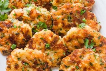 Cheesy Shrimp Cakes aka Shrimp Fritters with irresistible lemon aioli sauce. One of our favorite shrimp recipes! Biting into juicy shrimp, fritter style, is a real treat. The cheese creates an irresistible cheese pull inside and forms a golden crust on the outside. Watch the Video tutorial and you will just know; this recipe is GOOD | natashaskitchen.com